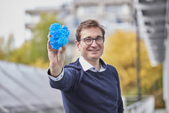 Tobias Erb is showing a 3D-Model of an optimized CO2 fixating enzyme.